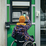 Woman in wheelchair using ADA compliant ATM